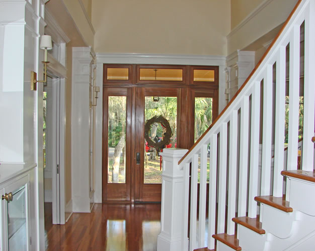 Foyer with custom wood entry door, staircase and heart-pine floors